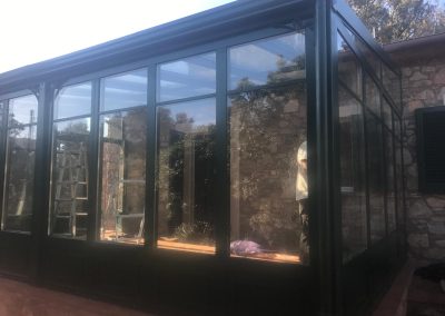Veranda in ferro verde scuro con vetri